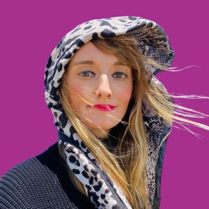 Alexa Kyler - a headshot of a woman on a pink background.